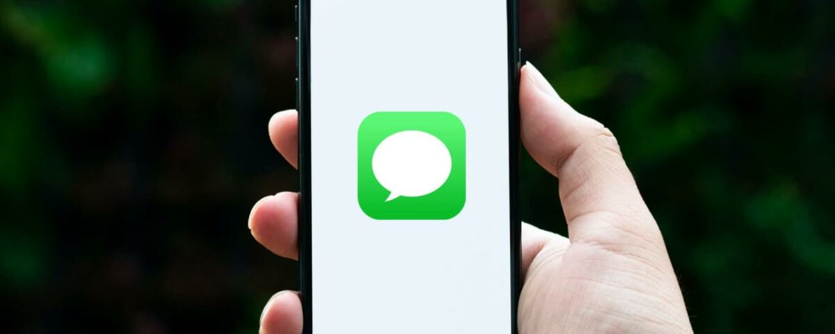 Sosteniendo el iPhone con el icono de la aplicación Mensajes en la pantalla