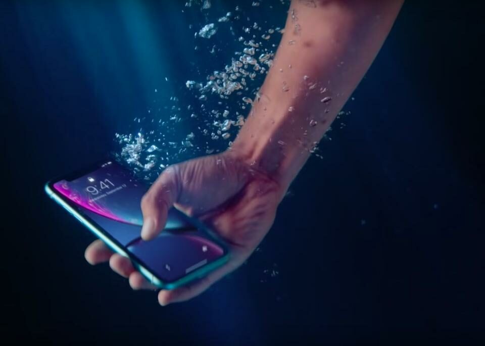 Sosteniendo un iPhone bajo el agua