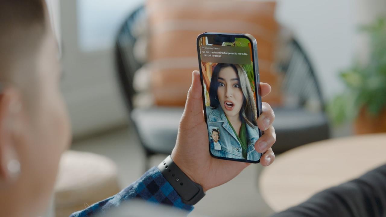 Una fotografía que muestra un iPhone sostenido en la mano de una persona, demostrando la función Live Captions en acción durante una videollamada de FaceTime