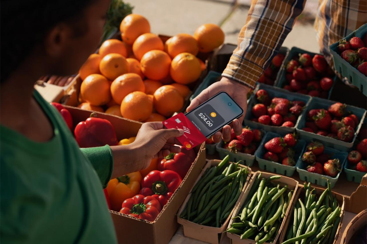Imagen de marketing de Apple que muestra a una mujer joven tocando su iPhone con una tarjeta de crédito habilitada para NFC para usar la función de pago sin contacto Tap to Pay en Apple Pay