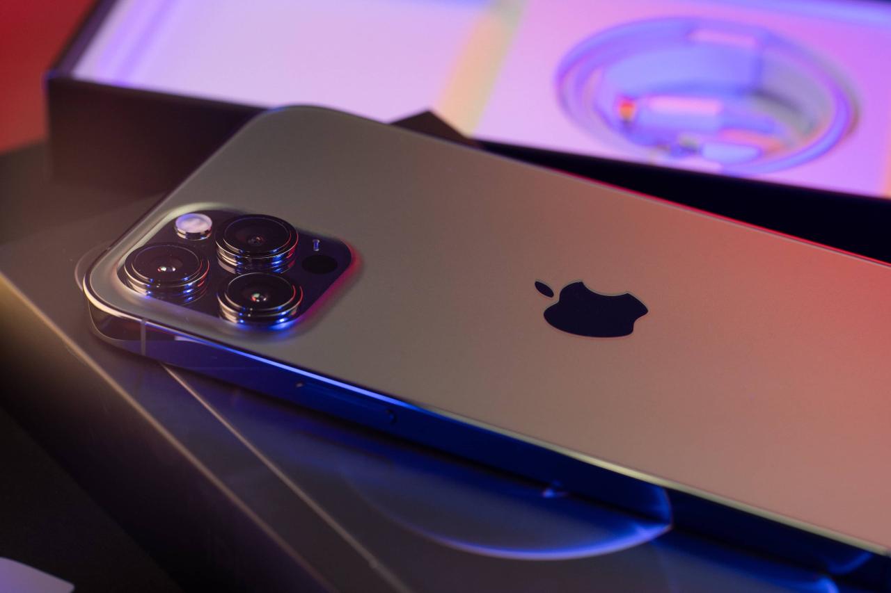 Una fotografía que muestra el Apple iPhone 13 Pro Max colocado boca abajo sobre su empaque, mostrando las cámaras traseras expuestas