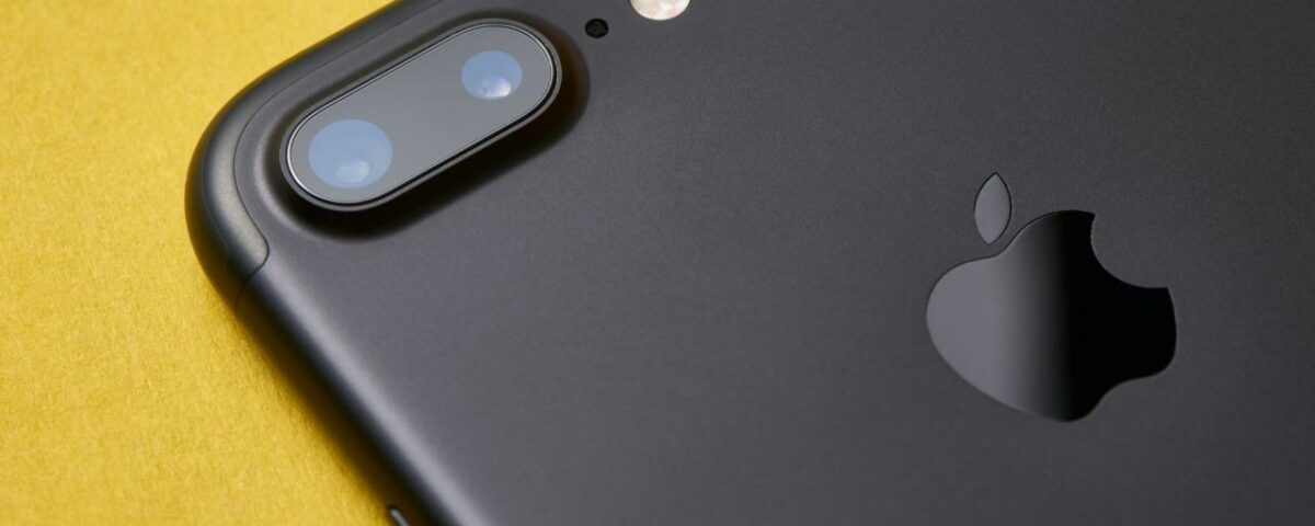 Un primer plano de un iPhone 7 Plus negro mate que muestra la cámara trasera de doble lente y el detalle del flash LED
