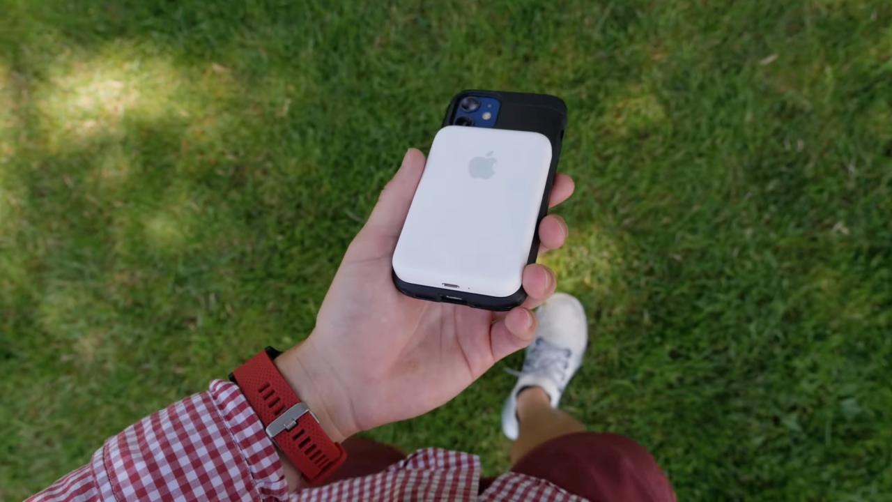 Una foto que muestra a una persona caminando por el parque, sosteniendo un iPhone 12 con el paquete de baterías MagSafe de Apple encajado en la parte posterior