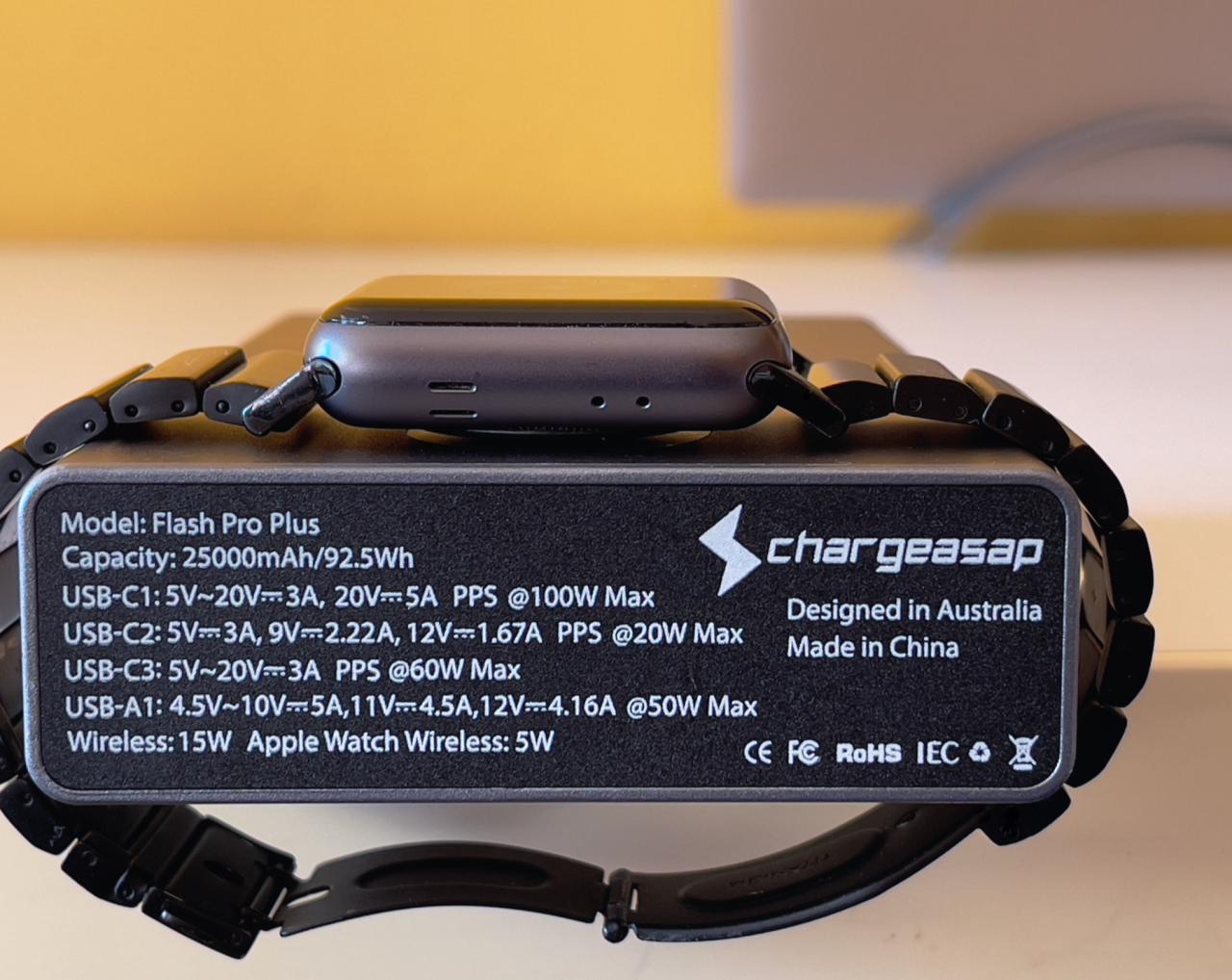 Una fotografía que muestra la parte trasera del banco de energía portátil Flash Pro Plus de Chargeasap con Apple WAtch cargándose de forma inalámbrica en la almohadilla magnética