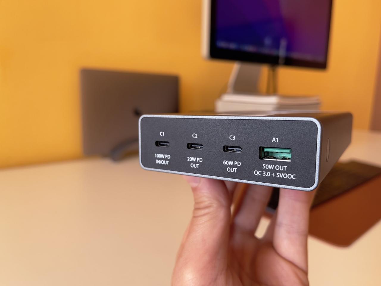 Una fotografía que muestra la vista trasera del banco de energía portátil Flash Pro Plus de Chargeasap descansando sobre los dedos de un hombre, con todos los puertos USB visibles en la imagen