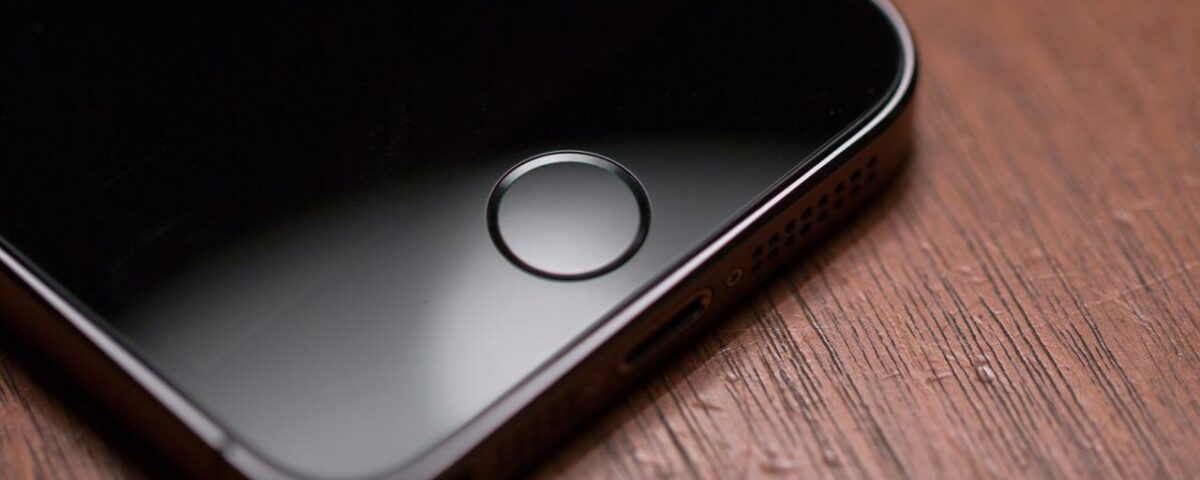 Una fotografía que muestra un iPhone colocado sobre una mesa con el foco en el botón Touch ID