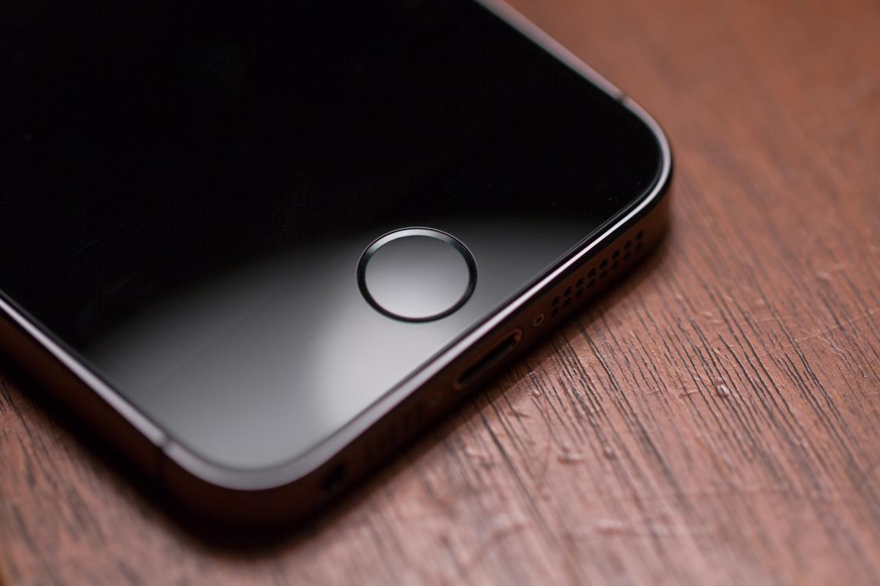 Una fotografía que muestra un iPhone colocado sobre una mesa con el foco en el botón Touch ID