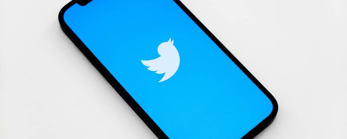 Vista isométrica de un iPhone que muestra el logotipo de un pájaro de Twitter blanco en la pantalla, sobre un fondo azul claro vendido