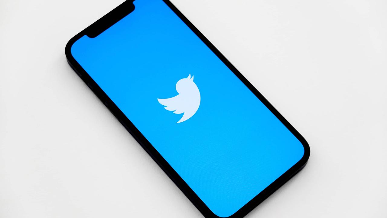 Vista isométrica de un iPhone que muestra el logotipo de un pájaro de Twitter blanco en la pantalla, sobre un fondo azul claro vendido